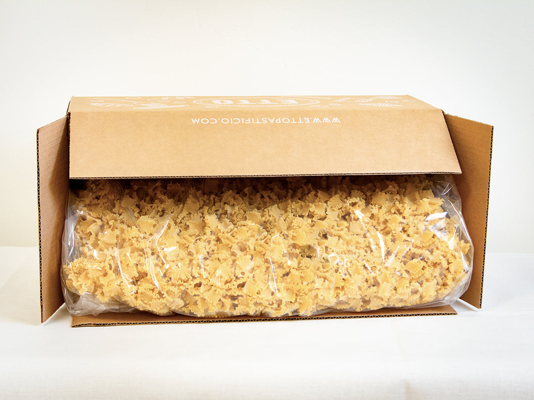 Box of reginette pasta with a clear plastic wrap on a white background