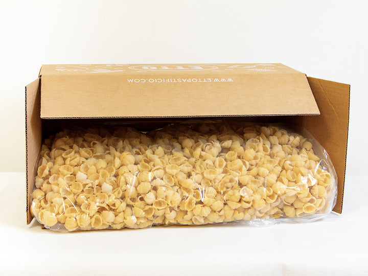 Box of pasta with a clear plastic bag inside on a white background